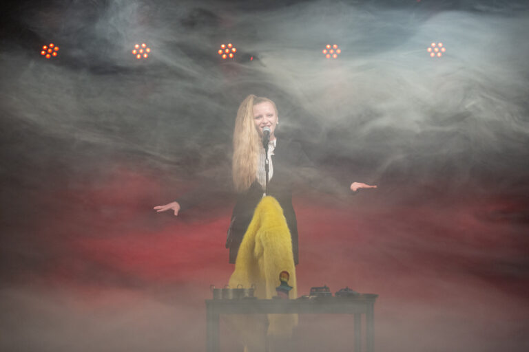 zdjęcie; aktorka na środku sceny w dymie