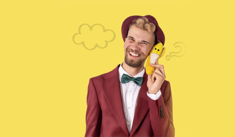 Magik Gapcio na żółtym tle trzyma banana przy uchu jak telefon