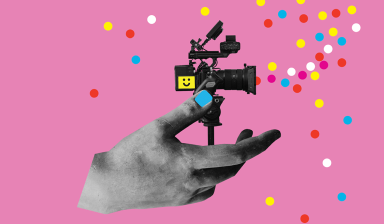 Kolaż na różowym tle. Duża czarno-biała dłoń podtrzymuje kamerę filmową na statywie. Na kamerze znajduje się żółty kwadrat z uśmiechniętą buźką, a na dłoni niebieski prostokąt. Wokół rozmieszczone są kolorowe kropki w kolorach żółtym, czerwonym, niebieskim, różowym i białym.
